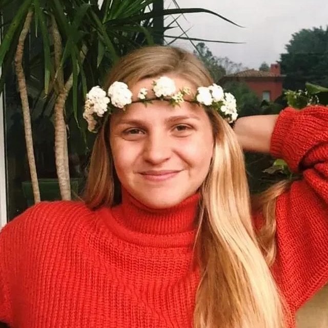 Tati in a red sweater and a flower crown