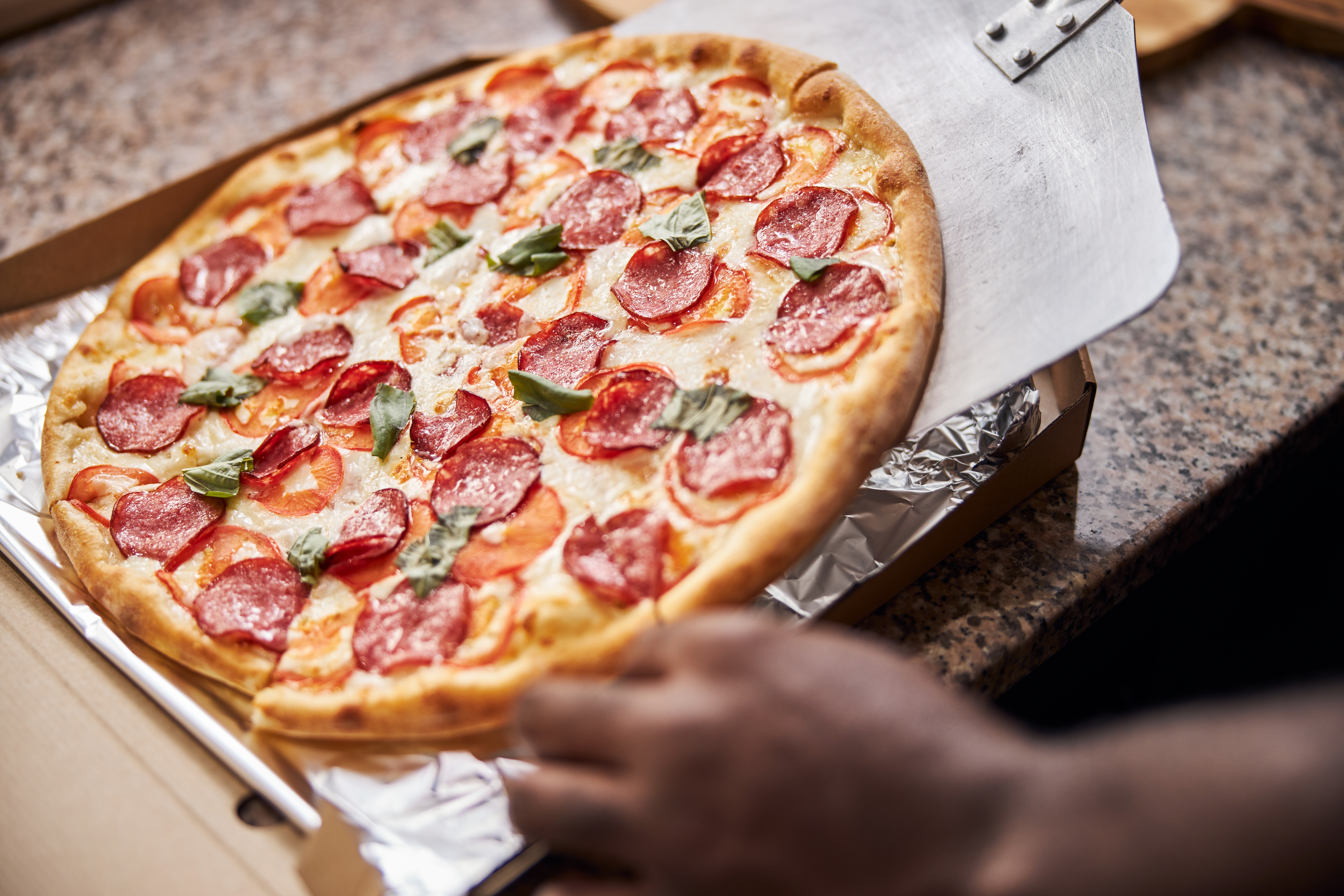 Male employee putting pizza in box